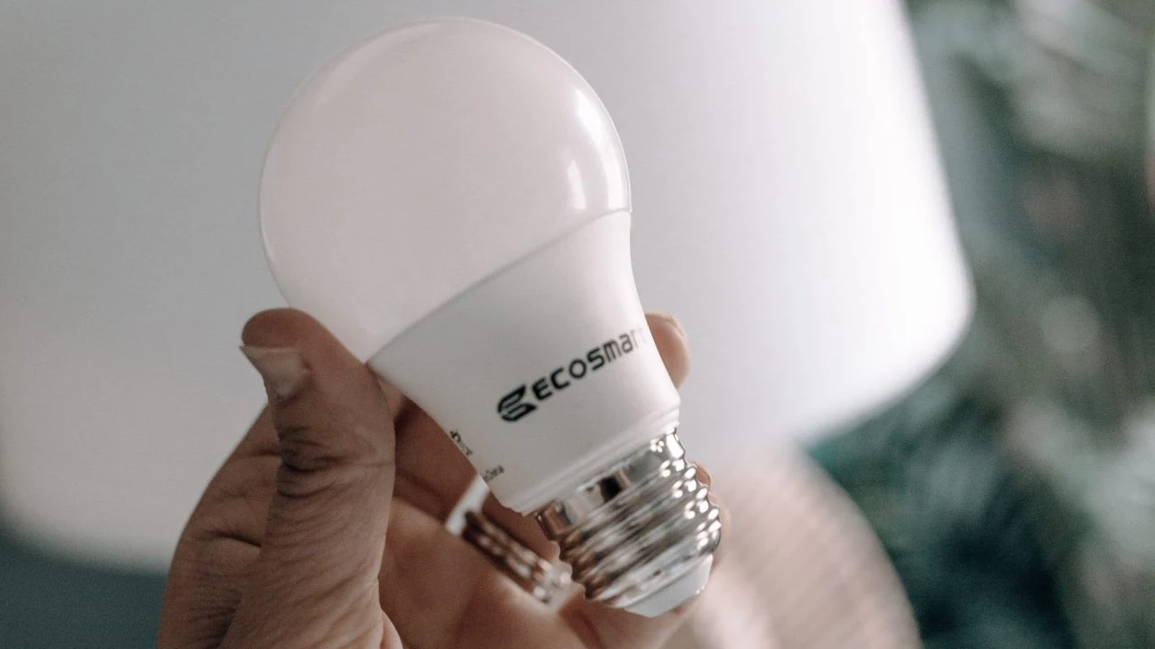 blue bowl of black bean beef tortilla soup on a board with cilantro and shredded cheese in background